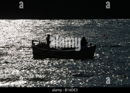 Mill Bay, Salcombe, Devon. Bateau dans l'estuaire avec les marins, silhouette Banque D'Images