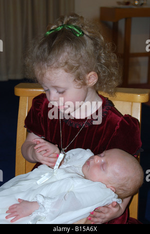 Young Girl holding baby au baptême, Gosport, Hampshire, Angleterre, Royaume-Uni Banque D'Images