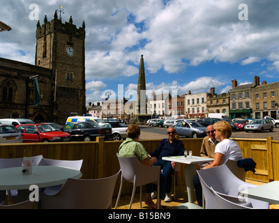 Les gens assis dans un café en plein air dans l'église Trinity Square Richmond North Yorkshire Banque D'Images