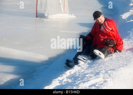 Les joueurs de hockey sur glace assis sur la neige Banque D'Images