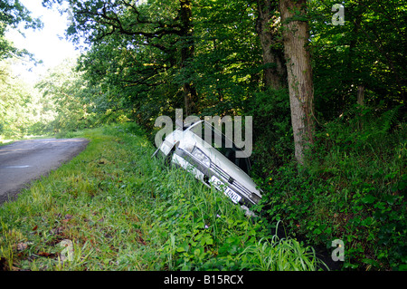 Peugeot 405 couché dans un fossé avec la police au courant sur l'autocollant de fenêtre latérale Banque D'Images