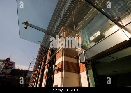 Une caméra de sécurité veille sur l'entrée d'un immeuble de bureaux nouvellement construit. Banque D'Images