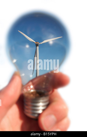 Wind turbine in blue sky par main tenant l'ampoule. Isolé sur blanc. Banque D'Images