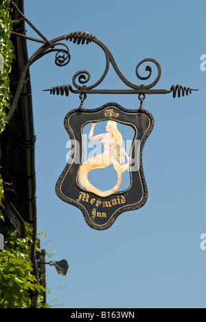 Close up vertical d'une vieille enseigne de pub en fer forgé noir à l'extérieur d'un bâtiment tudor suspendu dans le seigle sur une journée ensoleillée. Banque D'Images