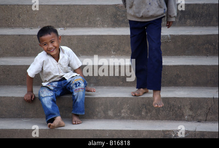 Laos Enfants attendant sur les marches Banque D'Images