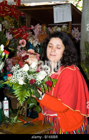 Dh mercado dos Lavradores Funchal Madeira Flowerseller en costume traditionnel l'organisation bouquet de fleurs Banque D'Images