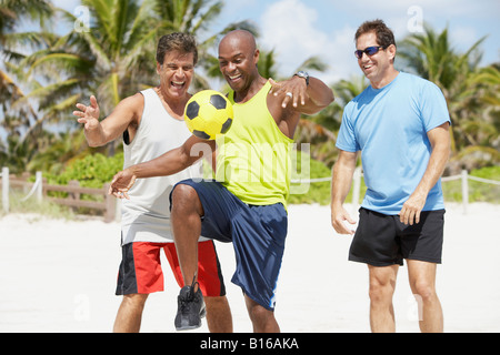 African American man bouncing soccer ball on knee Banque D'Images