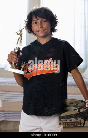 Mixed Race boy holding sports trophy Banque D'Images