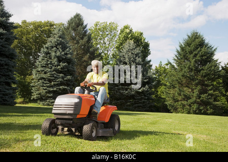 African American man mowing lawn Banque D'Images