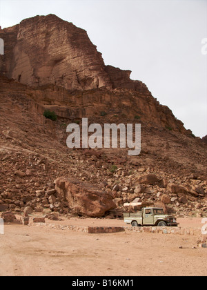 Une voiture en bas d'une falaise au milieu de la Wadi Rum, Jordanie Banque D'Images