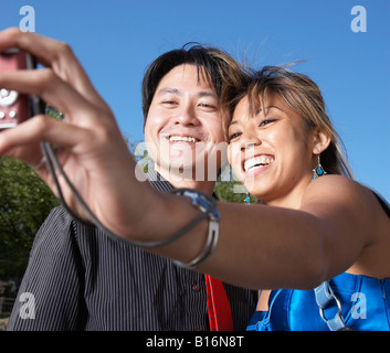 Asian couple taking own photograph Banque D'Images