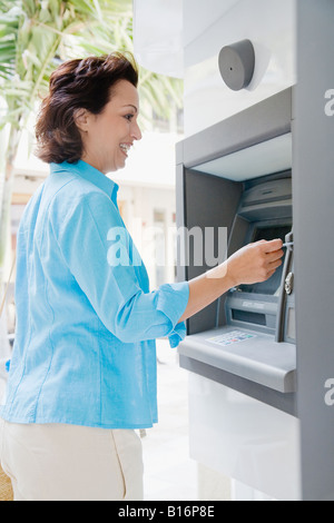 Hispanic woman avec automatic teller machine Banque D'Images