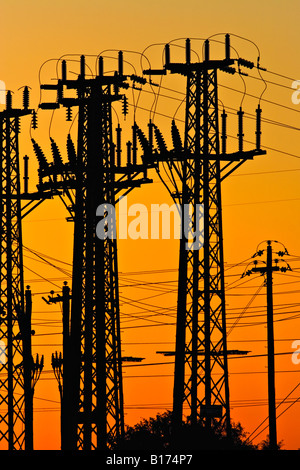 L'industrie de l'énergie / l'électricité. Une tour de transmission de haute tension qui se profile au coucher du soleil. Banque D'Images