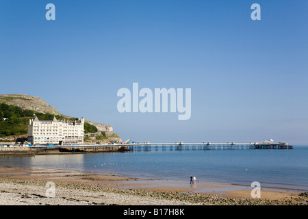 Plage du Nord tranquille avec Le Grand Hôtel et l'embarcadère de station touristique sur la côte galloise Llandudno North Wales UK Banque D'Images