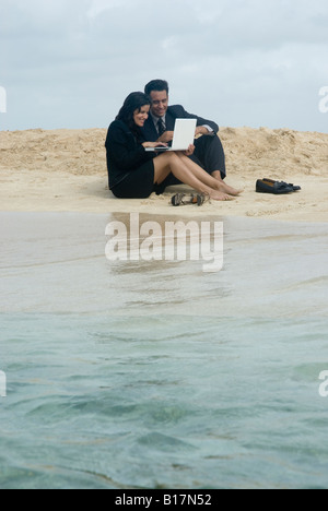Hispanic businessman working at beach Banque D'Images