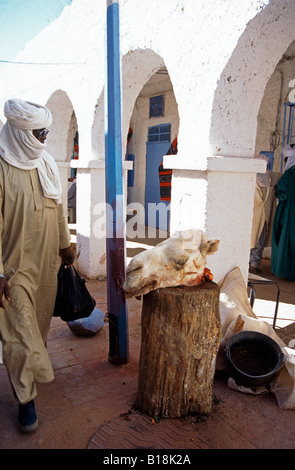 Tuareg passant devant la tête de chameau dans le marché à l'oasis de Djanet, Sahara algérien, Afrique du Nord Banque D'Images