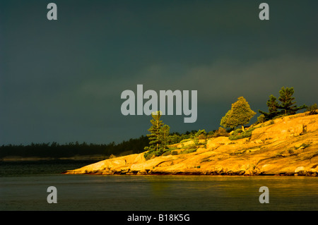 De granit rose entouré d'un ciel orageux et eaux sombres, Killbear Provincial Park, Ontario, Canada Banque D'Images
