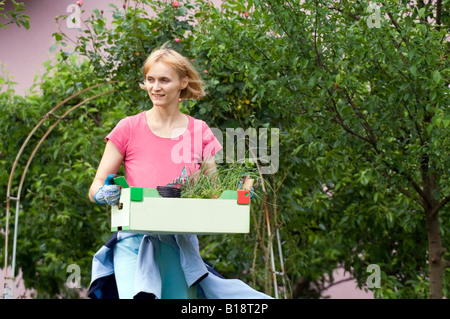 Femme travaillant dans le jardin, la plantation de certains végétaux. Banque D'Images