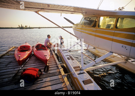 Couple avec kayaks sur dock, Otter Falls, parc provincial de Whiteshell, Manitoba, Canada. Banque D'Images