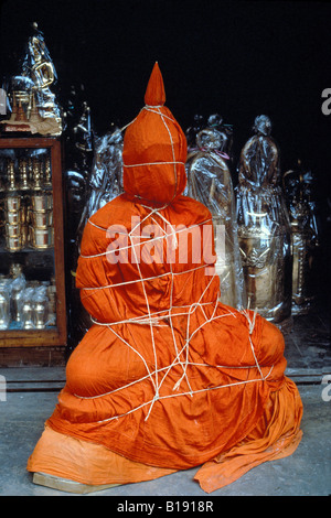 La vie d'un bouddha taille est enveloppée d'un tissu safran et lié avec une corde dans un magasin situé à Bangkok en Thaïlande Banque D'Images