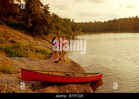 Couple avec canoë le long du lac Big Whiteshell, parc provincial de Whiteshell, Manitoba, Canada Banque D'Images
