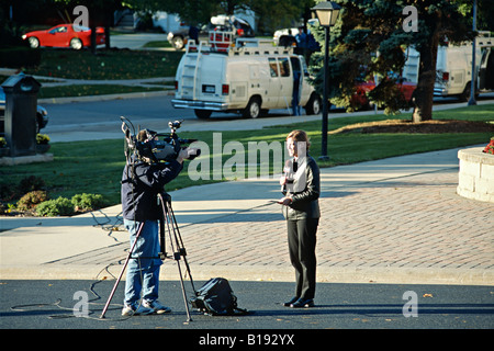 L'Illinois Wheaton travailleurs reporter cameraman vidéo avec emplacement distant van en arrière-plan rue de banlieue Banque D'Images