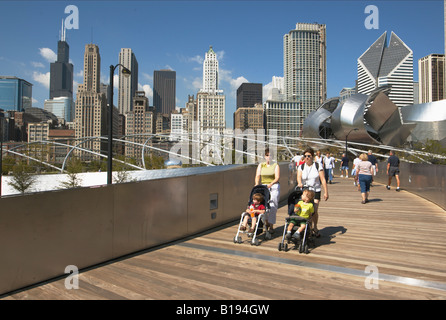 Parcs Chicago Illinois BP Bridge design Frank Gehry dans le Parc du millénaire les courbes en acier inoxydable skyline beaucoup de personnes sur le pont Banque D'Images