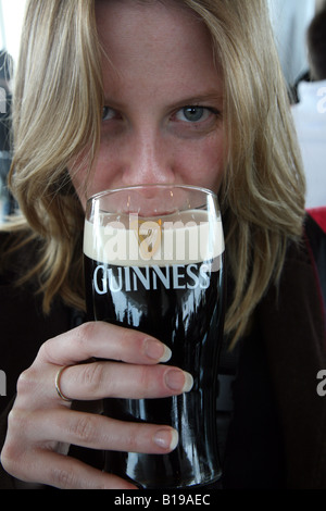 Une femme à boire de la Guinness à Dublin Banque D'Images