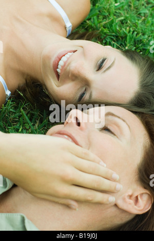 Mère et fille ado allongé sur le sol, girl touching woman's face, portrait Banque D'Images