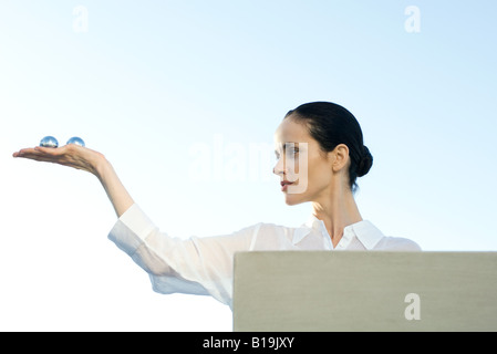 Woman holding Yin Yang balls en main, low angle view Banque D'Images