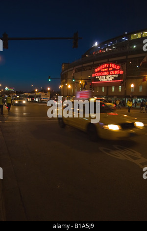 Un taxi s'engouffre par Wrigley Field comme les Cubs jouent un jeu de nuit dans le célèbre stade de Chicago, IL. Banque D'Images