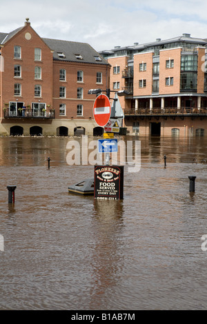 Ouse de rivière gonflée et bancs d'éclatement (route inondée au bord de la rivière, panneaux et bollards submergés, eaux fortement inondées) - York, North Yorkshire, Angleterre, Royaume-Uni. Banque D'Images