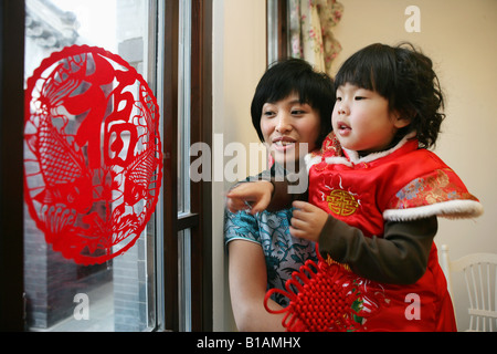 Chinese mother holding her daughter smiling at camera Banque D'Images