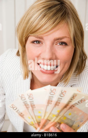 Woman holding 50 Euro, smiling, portrait Banque D'Images
