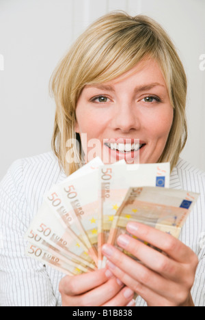 Woman holding 50 Euro, smiling, portrait Banque D'Images