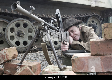 La Seconde Guerre mondiale soldat mitrailleuse tirant à côté de tank Banque D'Images