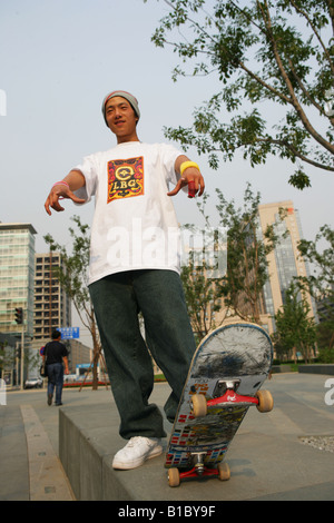 Young man looking at camera with skateboard Banque D'Images