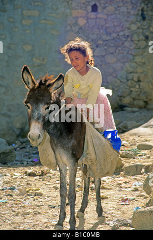 Jeune fille yeminite équitation sur la âne (Equus asinus) Banque D'Images