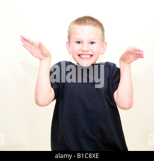 Garçon aux cheveux blonds dans un studio faisant un drôle de visage Banque D'Images