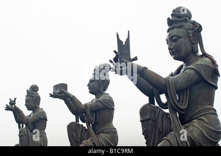 Statues bouddhiques en faisant des offrandes à l'Tian Tan Buddha sur un jour brumeux. Monastère Po Lin, Ngong Ping, Lantau Island, Hong Kong Banque D'Images