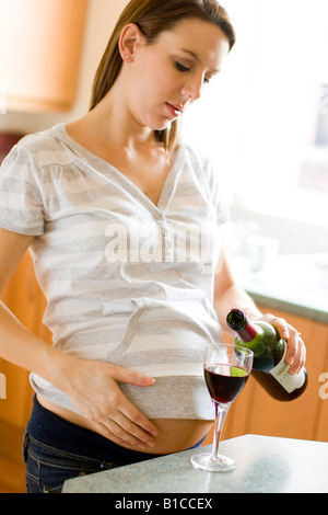 Inquiet à la femme enceinte de boire du vin Banque D'Images