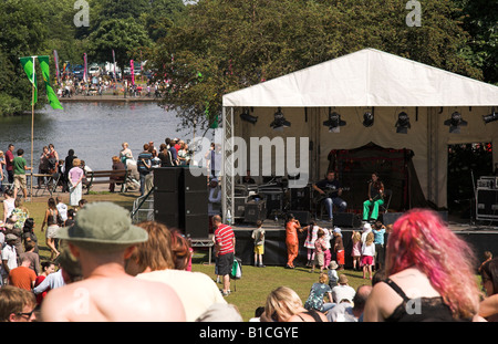 Des gens assis sur l'herbe en regardant une bande, FÊTE ! Festival, pique-nique au lac, Platt Fields Park, Fallowfield, Manchester, UK Banque D'Images
