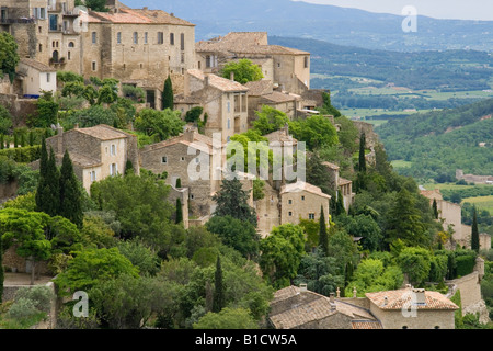 Sur Gordes, village construit au sommet d'une montagne dans la région de Vaucluse Provence, France topiaried avec maisons et jardins. Banque D'Images