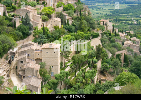 Sur Gordes, village construit au sommet d'une montagne dans la région de Vaucluse Provence, France topiaried avec maisons et jardins. Banque D'Images