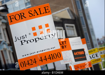 Hastings agent immobilier pour la vente des conseils jostle pour la meilleure position sur une rue résidentielle. Photo de Jim Holden. Banque D'Images