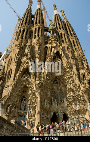 Les touristes à l'entrée avant d'Antoni Gaudi, La Sagrada Familia admirer sculptures statues et figures de la façade de la Nativité Banque D'Images