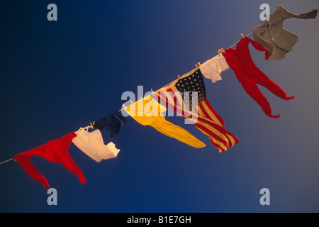 US Flag et uniformes sur la ligne de vêtements dans le vent contre le ciel bleu USA Banque D'Images