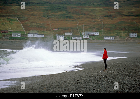 Femme regardant les vagues déferlent sur la plage près du village de Broom Point Terre-Neuve Canada Automne Banque D'Images