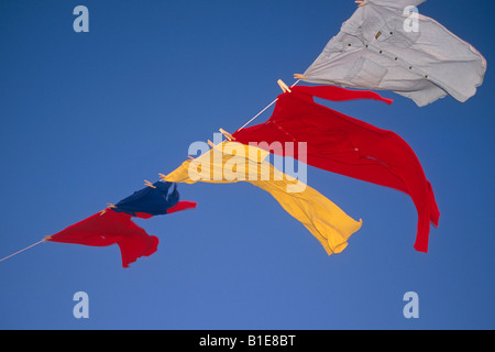 US Flag et uniformes sur la ligne de vêtements dans le vent contre le ciel bleu USA Banque D'Images