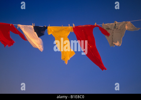 US Flag et uniformes sur la ligne de vêtements dans le vent contre le ciel bleu USA Banque D'Images